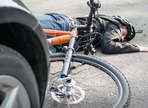 Verunglückter Fahrradfahrer liegt auf der Straße